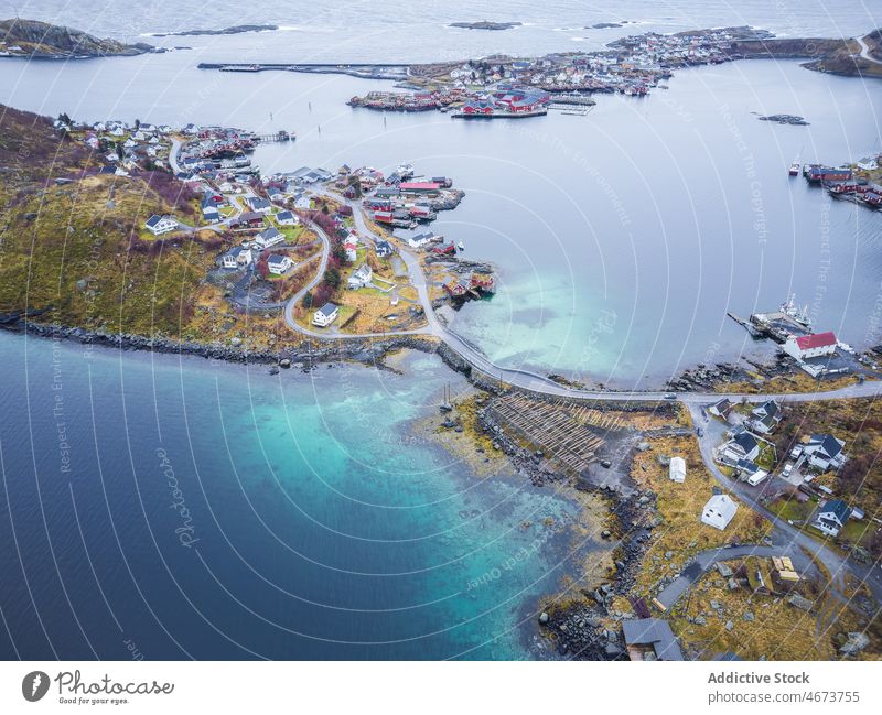 Islands with buildings near sea island archipelago house water road town coast waterfront bridge residential Reine norway lofoten calm scenic clear grassy