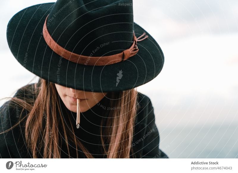 Woman in hat smoking cigarette woman smoke smoker habit street style nicotine tobacco addict joint female lady town light appearance unhealthy attractive glad