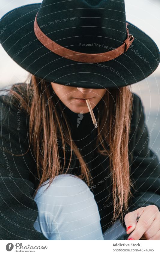 Woman in hat smoking cigarette woman smoke smoker habit street style nicotine tobacco addict joint female lady town light appearance unhealthy attractive glad