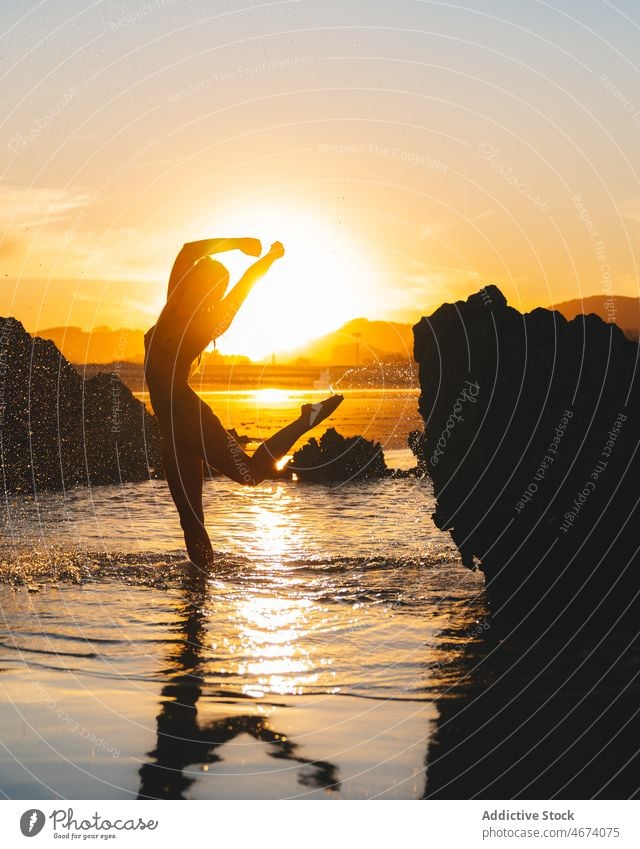 Anonymous man splashing water in sea at sunset time naked torso leisure pastime recreation nature evening body dusk sunlight sunshine environment undress