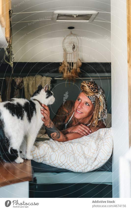 Positive woman near cat in van owner traveler pet animal feline camper creature road trip trailer vehicle mammal fluff caress transport automobile collar