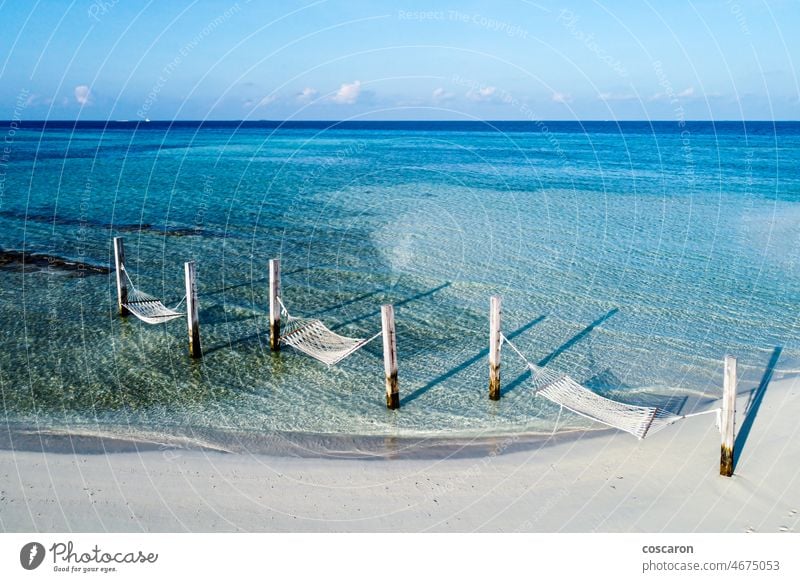 Three hammocks on a beach of the Maldive Islands aerial background beautiful blue coast coastline holiday idyllic indian ocean island landscape maldives