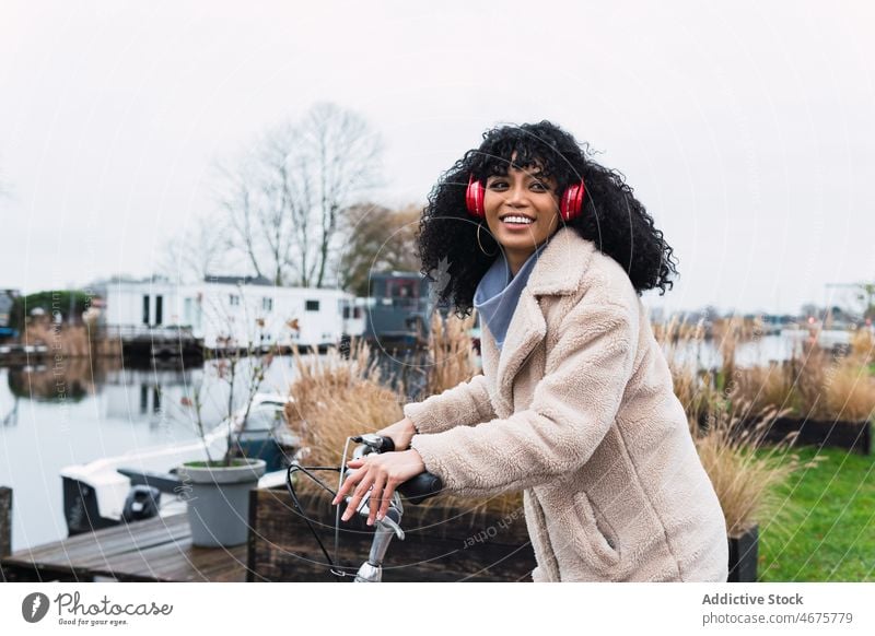 Woman in headphones riding bicycle woman using music listen ride bike chill city female portrait african american woman black woman relax street smile positive