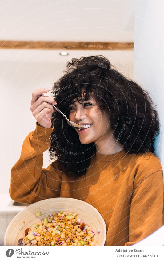 Cheerful black woman eating healthy salad kitchen healthy food vegetable home meal vitamin female african american woman tasty young positive smile delicious