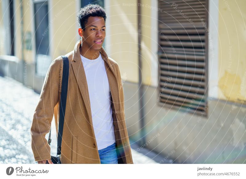 Young Cuban man standing in the street. black male cuban young person expression happy student outdoor looking casual lifestyle one adult guy african t-shirt