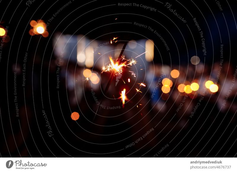 Festive background, bengal light on the dark background, New Year with sparklers sparks on a festive background. selective focus. night fire black glow shine