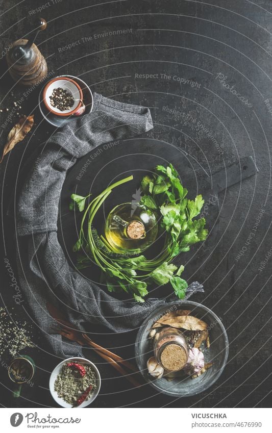 Food background with parsley, olive oil, round black cutting board, spices food kitchen utensils dark kitchen table cooking home fresh ingredients top view