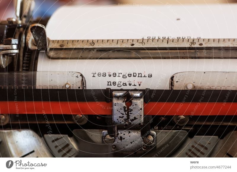 The German word test result negative written with an old mechanical typewriter with red-black ribbon in black color on a white sheet of paper Covid PCR test