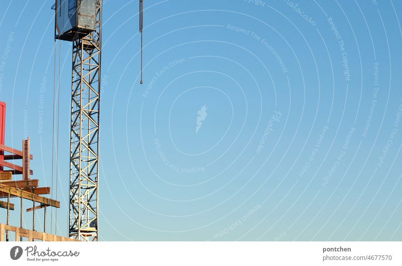 A construction site and a construction crane against blue sky. Construction work, house building Crane Construction site construction works Sky