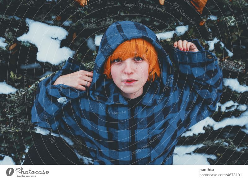 Redhead androgynous model in a winter scene people teen androgynious queer non-binary young youth cold hood hoodie redhead warm warmth thinkg alone wood