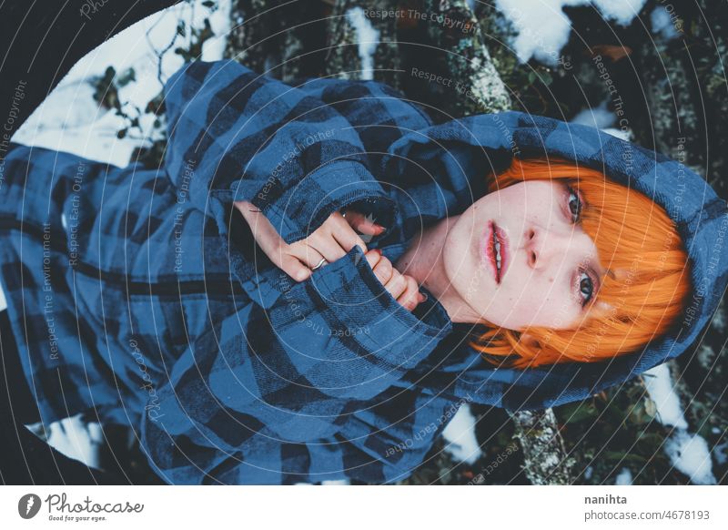 Redhead androgynous model in a winter scene people teen androgynious queer non-binary young youth cold hood hoodie redhead warm warmth thinkg alone wood