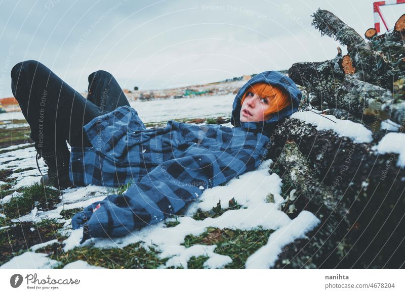 Redhead androgynous model in a winter scene people teen androgynious queer non-binary young youth cold hood hoodie redhead warm warmth thinkg alone wood