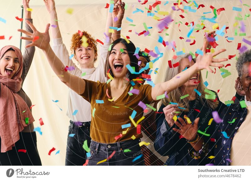 Action shot of mixed age range multi ethnic women celebrating International Women's Day with ticker tape international womens day iwd empowerment feminist