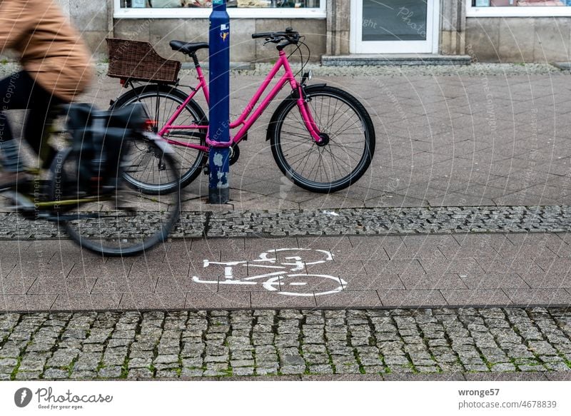 Bicycle lane with cyclist and bike secured to lamppost in city 2/2 Cycle path Shandy Town safeguarded Associated Transport Cycling Road traffic Mobility Driving