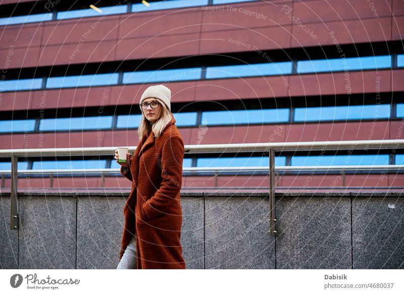 Woman at city street with coffee cup woman walking lifestyle eyeglasses urban crosswalk drink fashion business takeaway city life girl model road casual lady