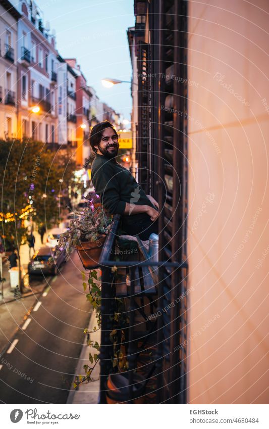 Casual young man smiling in the balcony on a typical Madrid building facade on a street casual handsome 20s 30s adult background caucasian center city comfort