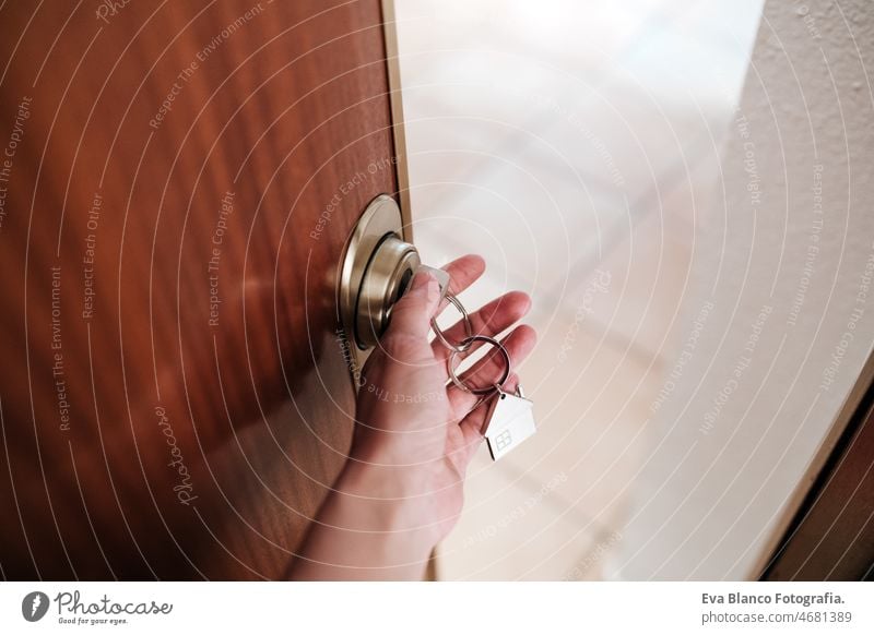 unrecognizable woman opening door home with keys and keyring with house shape.Home and lifestyle real state indoors door handle keyhole hardware neighborhood