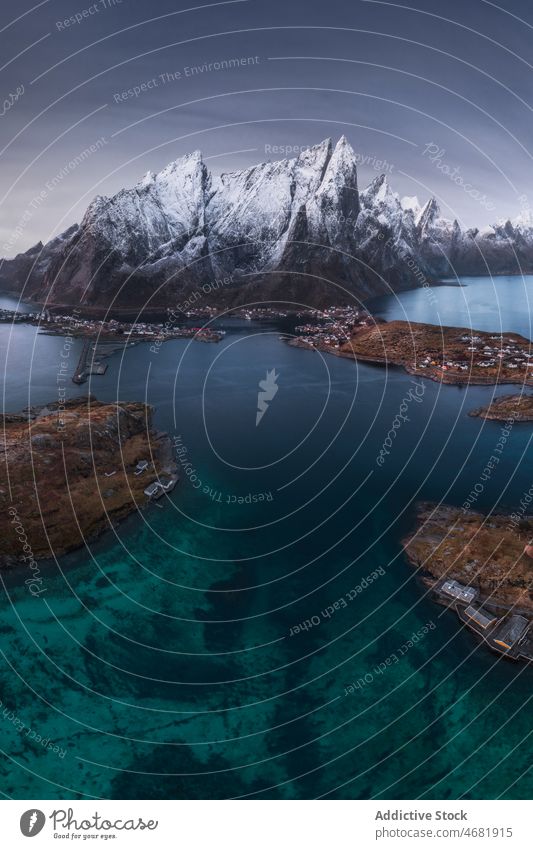 Mountainous terrain near sea in Norway island mountain nature sky Uttakleiv cloudy landscape environment formation rocky water seascape picturesque snow norway