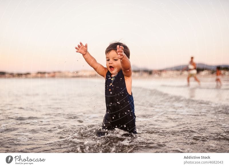 Cute boy walking in sea child water playful childhood leisure pastime resort shore cute summer adorable innocent splash recreation sweet amusement appearance