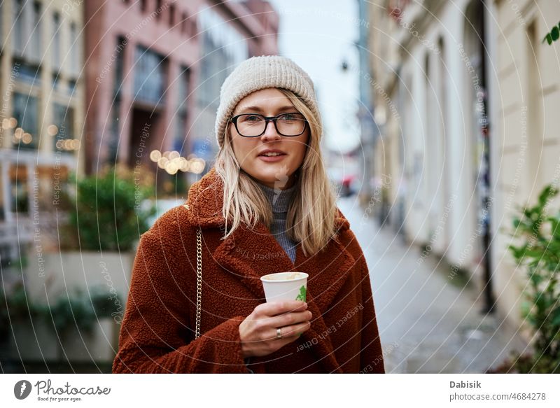 Woman at city street with coffee cup woman walking lifestyle eyeglasses urban crosswalk drink fashion business takeaway city life girl model road casual lady