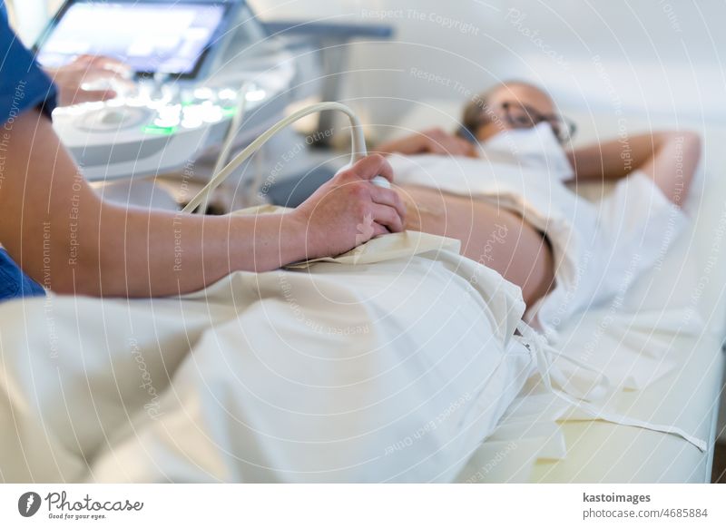 Close up of a pregnant woman having ultrasound scanning at the medical clinic. Healthcare and medicine concept. pregnancy expecting exam patient abdomen healthy