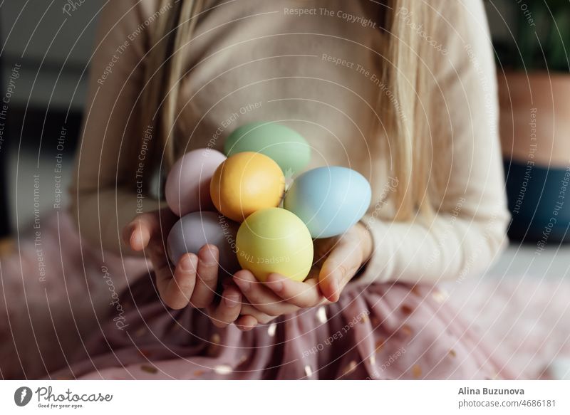 happy caucasian toddler girl eight years old at home in living room with colored easter eggs. Stay home during Coronavirus covid-19 pandemic holiday child kid