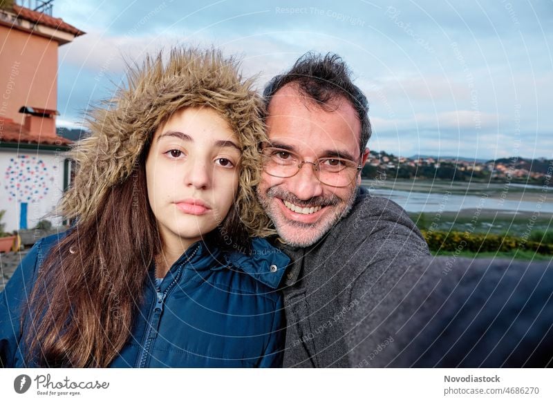 Portrait of two people, father and daughter, isolated outdoors, on a winter's day couple family outside portrait teenager girl caucasian happy young parent man