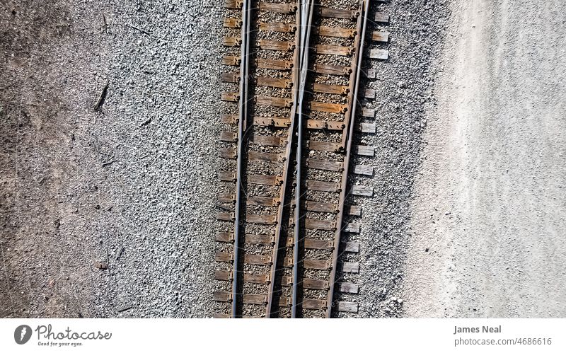 Aerial of pair of old rusty railroad tracks. surface gravel industrial industry transport ground flat view above grunge outside railyard dirty train outdoors