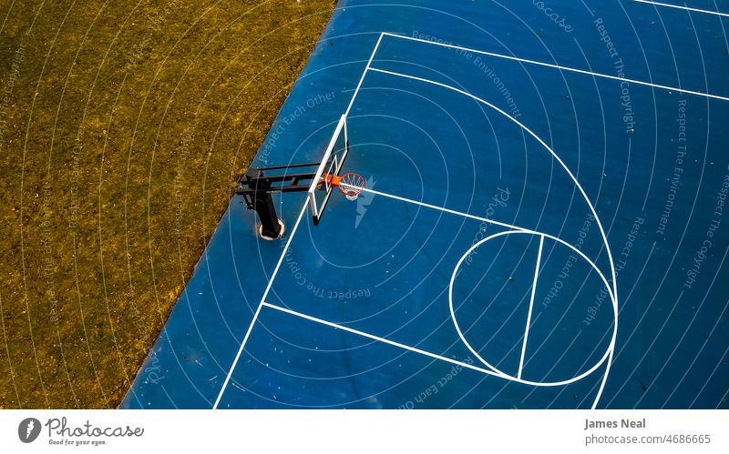 Blue Basketball court with clear hoop and grassy background autumn sunny color no people nature land summer drone net outside basket scenic arena outdoors day