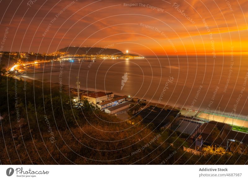 Glowing cit on shore in dark orange sunset waterfront sea seafront building city coastal evening glow seaside malecon lima peru la costa verde residential