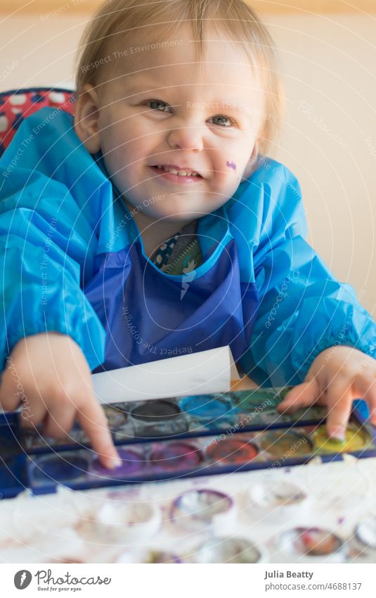 18 month old toddler water color painting with two hands at once; art time while seated in high chair grasp hold paint brush 18 months old