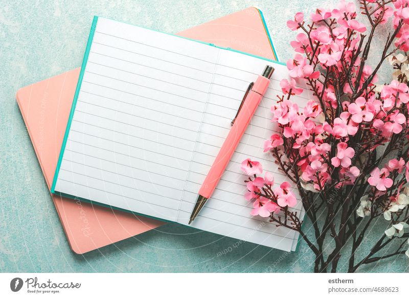 Top view of blank journal open with pink pen, almond blossoms and copy space top view diary textbook reading mock-up closeup paperback concept mock up planner