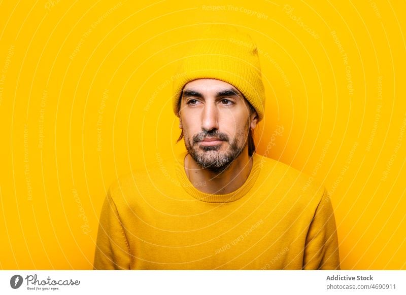 Man with eyes closed in yellow studio man appearance mood beard portrait male unshaven color colorful light friendly carefree guy vivid style unemotional