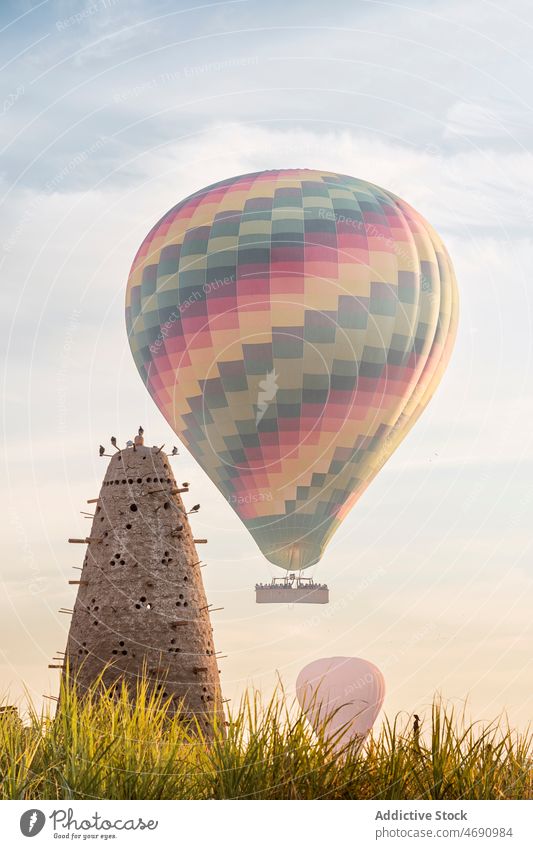 Bird tower on field near air balloons bird pigeon nesting egyptian culture hole architecture house stone wall building construction structure stick tall flock