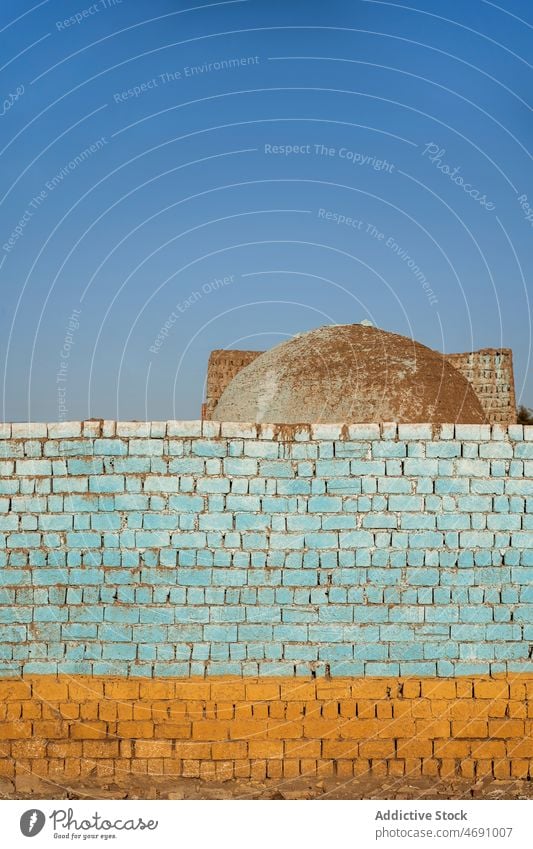 Old painted brick wall on street shabby weathered old building local style colorful town egypt worn out district structure city aged part light dome blue sky