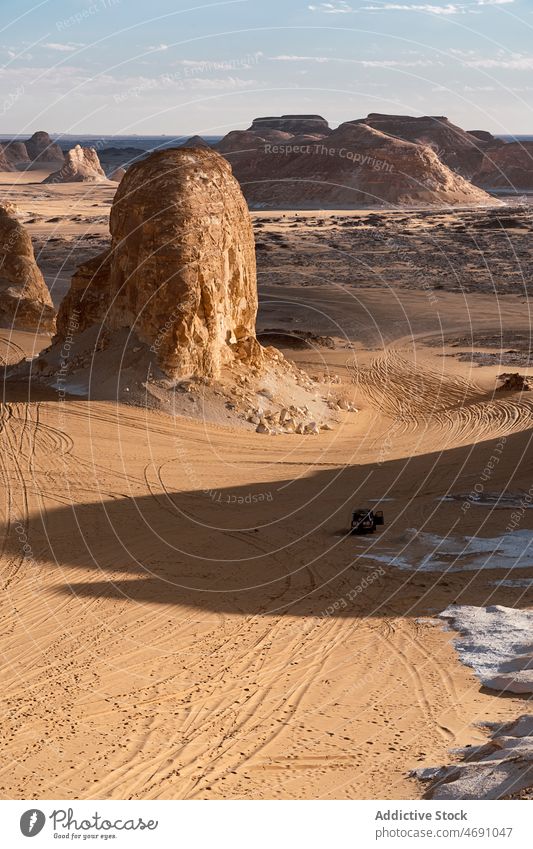 Automobiles driving through rocky formations in white desert arid nature national suv sand park dry heat location car destination scenery egypt africa vehicle