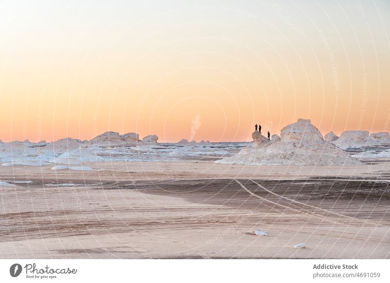 Travelers admiring endless white desert with rocky formations travelers arid nature national observe sand admire park dry heat location destination scenery