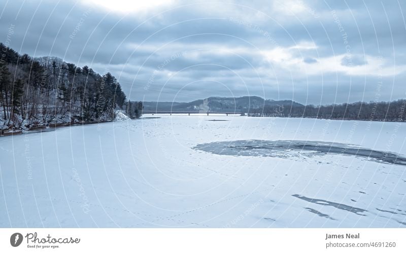 A gloomy day on the icy river tranquility bridge nature water frost beauty lake hill snow road tree wisconsin temperature outdoors environment dramatic winter