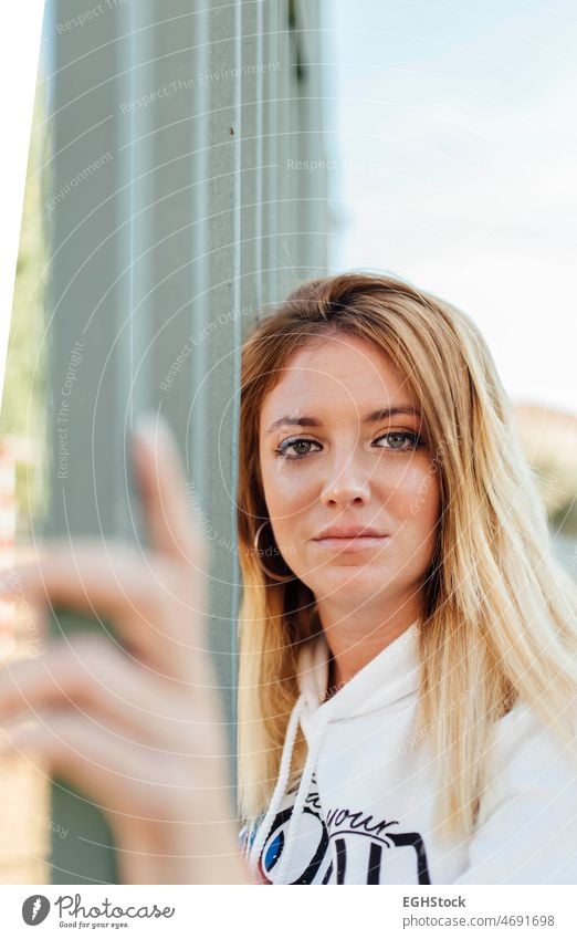 Portrait of blonde woman leaning her head against a fence and touching it with her hand Woman Fence person portrait Outdoors youthful Caucasian pretty Blonde