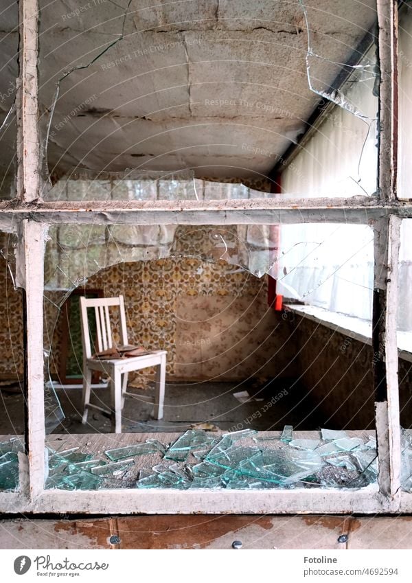 Only a chair and curtains in this room remind us that it used to be homey here. But even in this lost place, vandals were bent on destruction and smashed all the windows. Too bad!