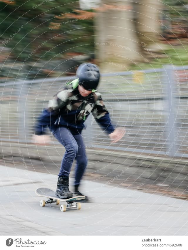 Boy rides skateboard on sidewalk as pull-along wipes out Boy (child) Skateboard steep Drag-along blurred Movement blurriness Skateboarding Joy Athletic