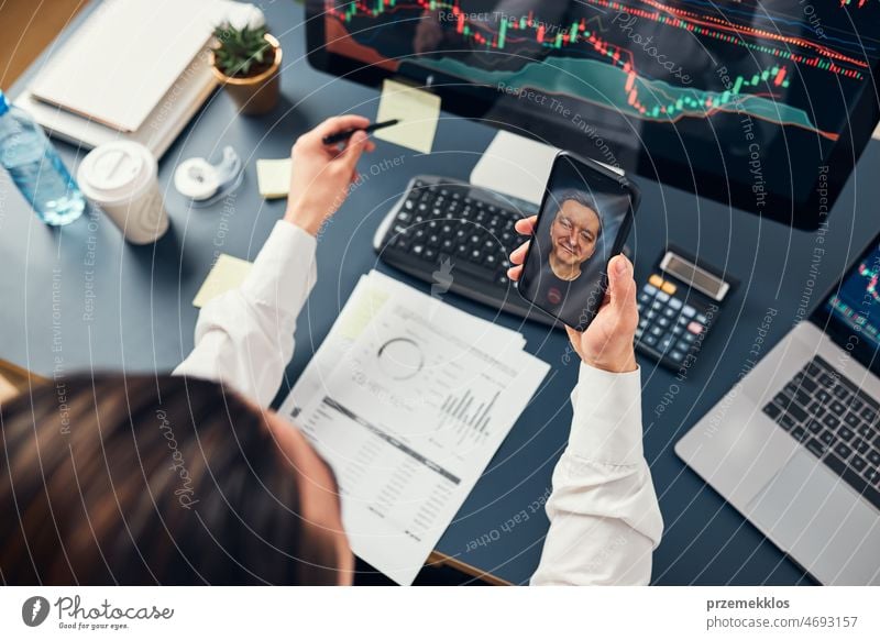 Businessman trading stocks online. Stock investor discussing numbers at graphs while video conversation with his colleague. Business team planning and analyzing stock market graphs. Business man investing stock online