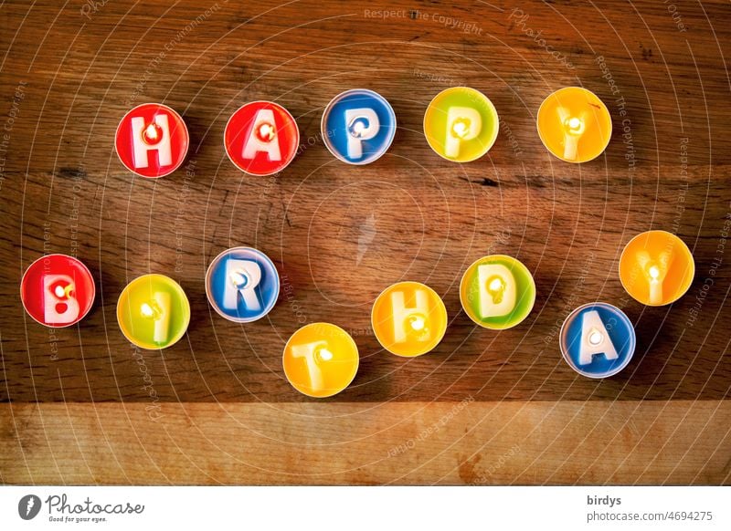 Happy birthday. Colorful , burning tea lights with letters as a birthday greeting . Birthday Tea lights Letters (alphabet) Happy Birthday variegated