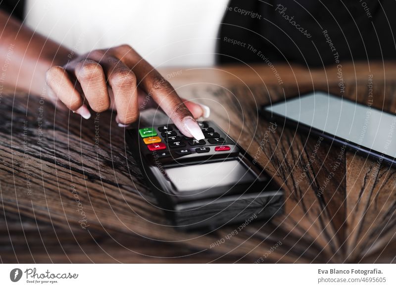 close up of woman doing contact less payment with mobile phone in cafe. technology and shopping unrecognizable women cafeteria purchase transaction lifestyle