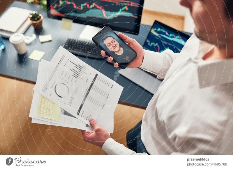 Businessman trading stocks online. Stock investor discussing numbers at graphs while video conversation with his colleague. Business team planning and analyzing stock market graphs. Business man investing stock online