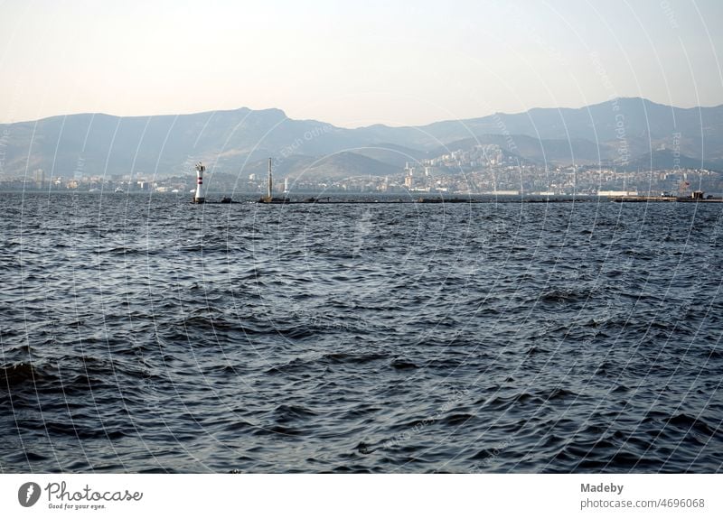 View from the pier in Konak district of Izmir bay and the coast with mountains in summer sunshine on the Aegean Sea in Turkey Returning home Kitsch Evening