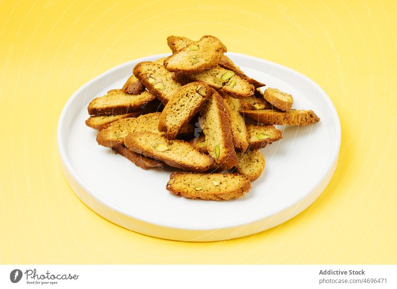 Heap of biscotti on white table dessert biscuit sweet confection confectionery treat cuisine culinary nut pistachio food fresh tasty delicious yummy appetizing