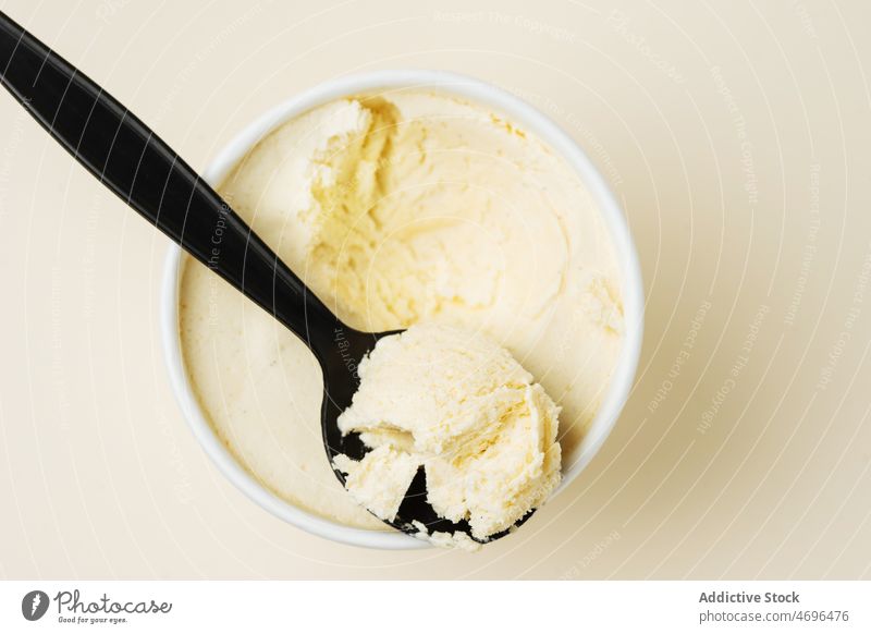 Ice cream bucket on white surface ice cream tub dessert cold sweet vanilla calorie flavor frozen treat delicious spoon yummy tasty sugar light fresh delectable