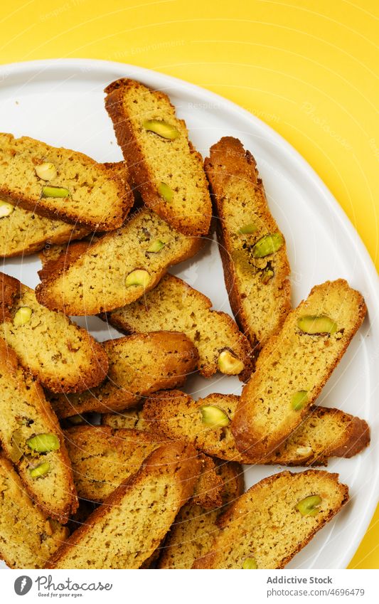 Heap of biscotti on white table dessert biscuit sweet confection confectionery treat cuisine culinary nut pistachio food fresh tasty delicious yummy appetizing