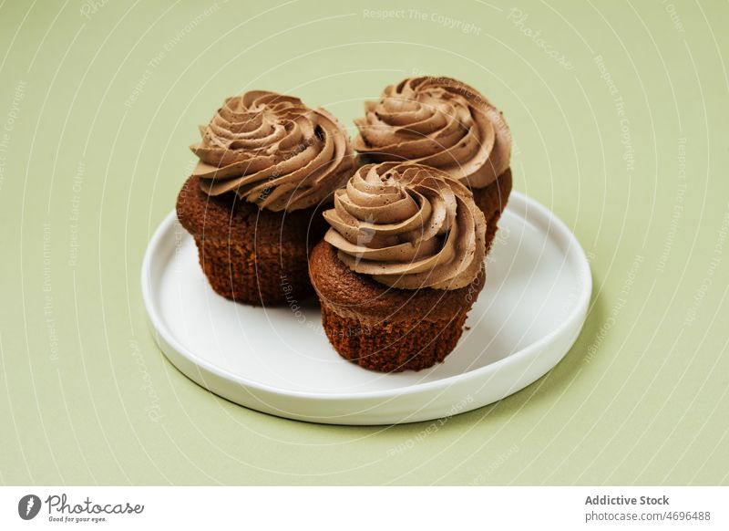 Chocolate cupcakes with frosting on plate chocolate dessert sweet confection pastry confectionery topping treat food fresh tasty delicious yummy appetizing